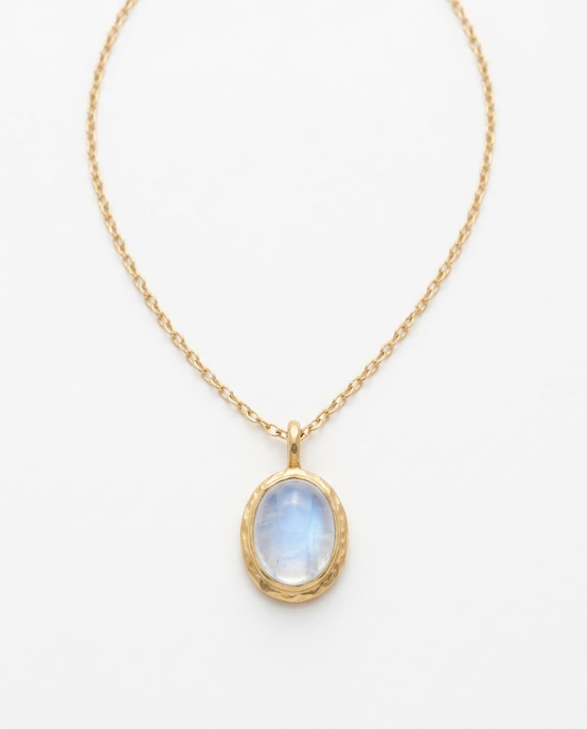 necklace photographed with bling ai — hammered gold, moonstone pendant