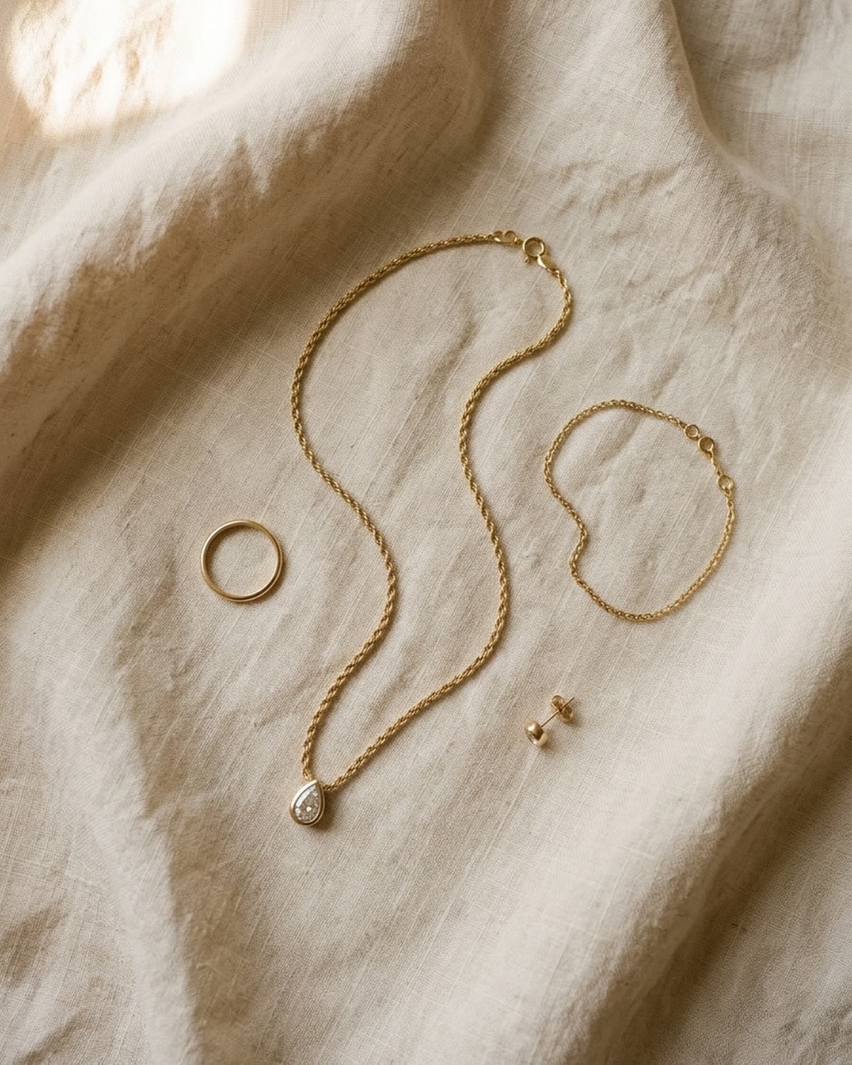 overhead jewelry photographed with bling ai — four-piece lay-flat on cream linen