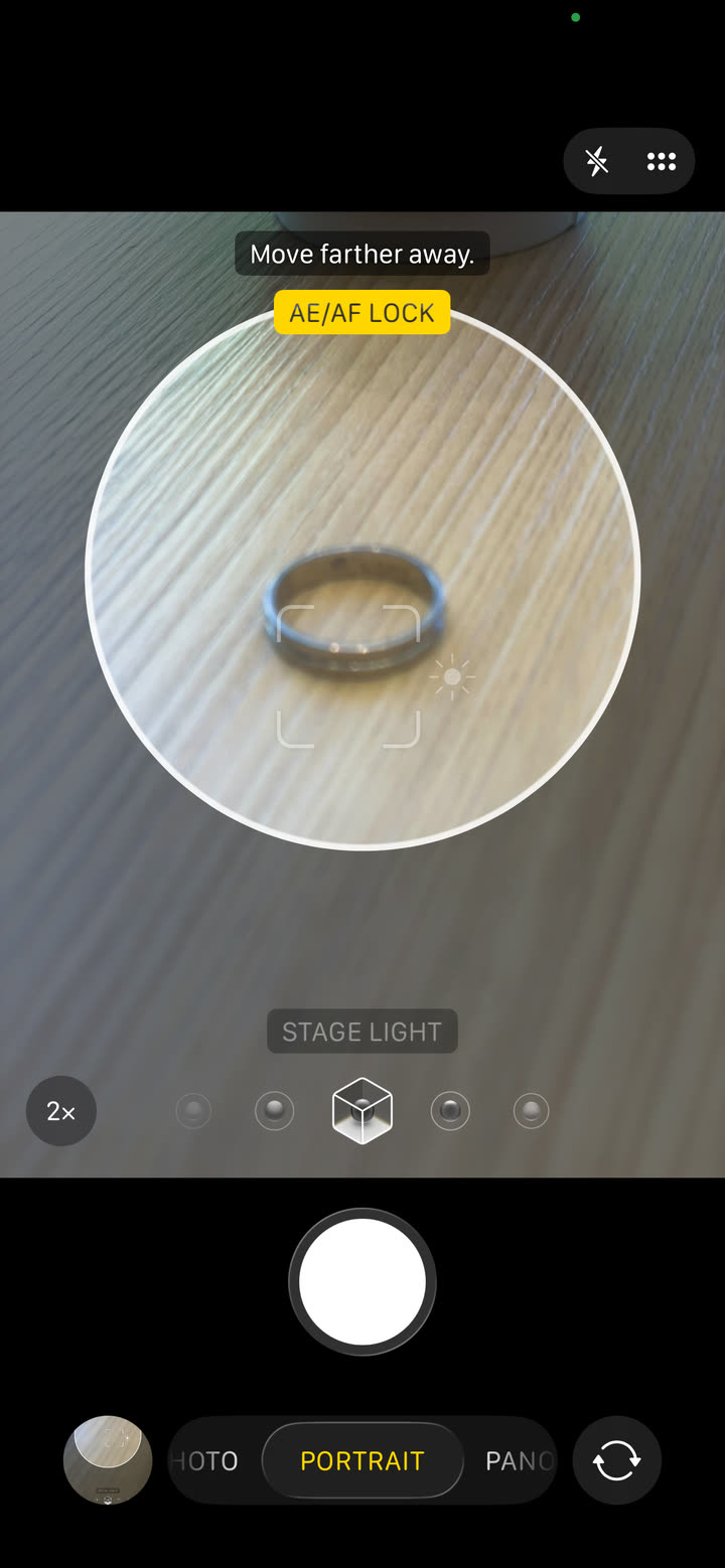iphone camera app in portrait mode with AE/AF LOCK active on a ring sitting on a wooden surface, exposure compensation visible